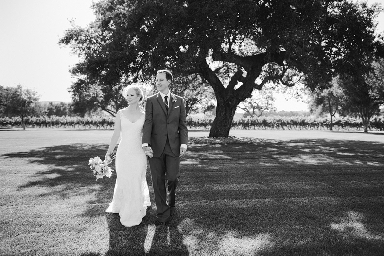 This is a photo of the bride and groom walking.