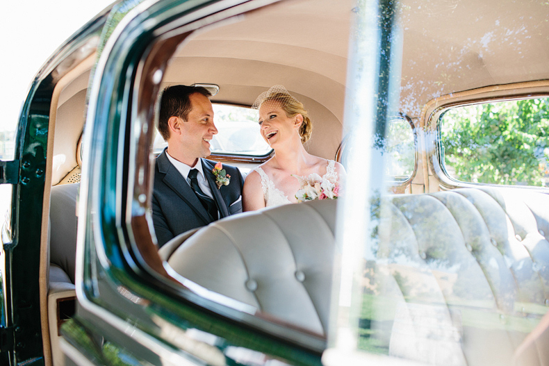 This is a photo of the bride and groom in the back of a car.