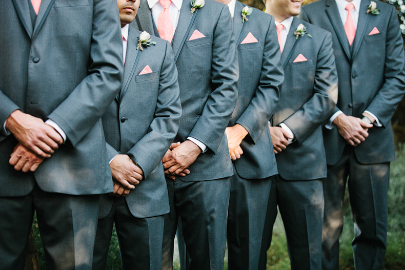 Groomsmen almost all standing with hands right over left.