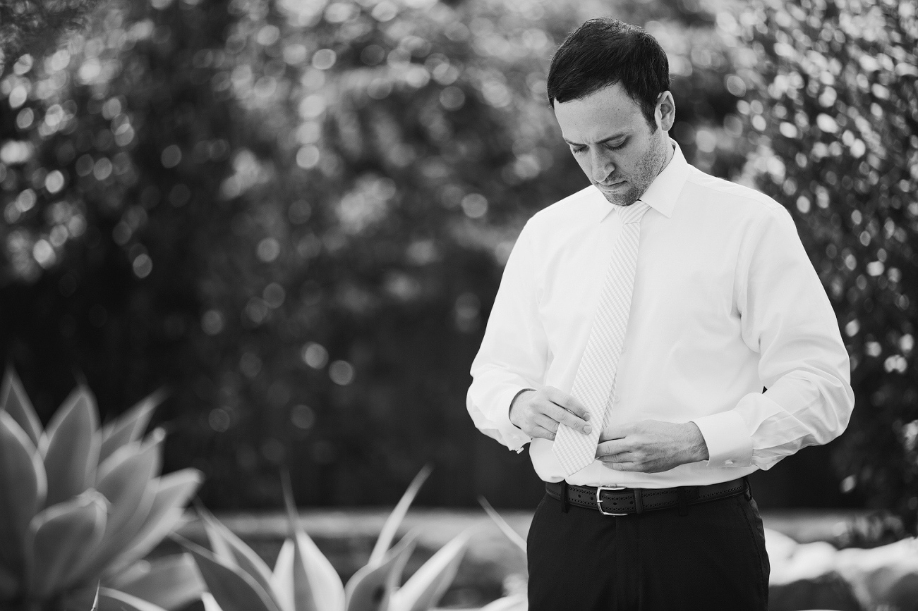 Andrew fixing his tie on his wedding day. 