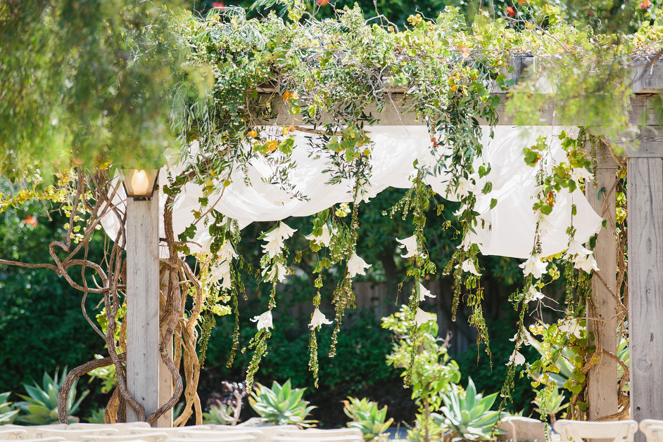 Flowers hanging from the ceremony arch.