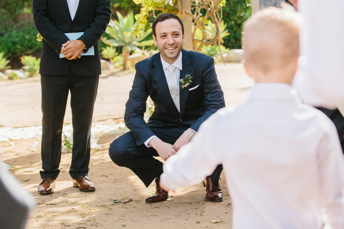 The ring bearer walking to the groom.