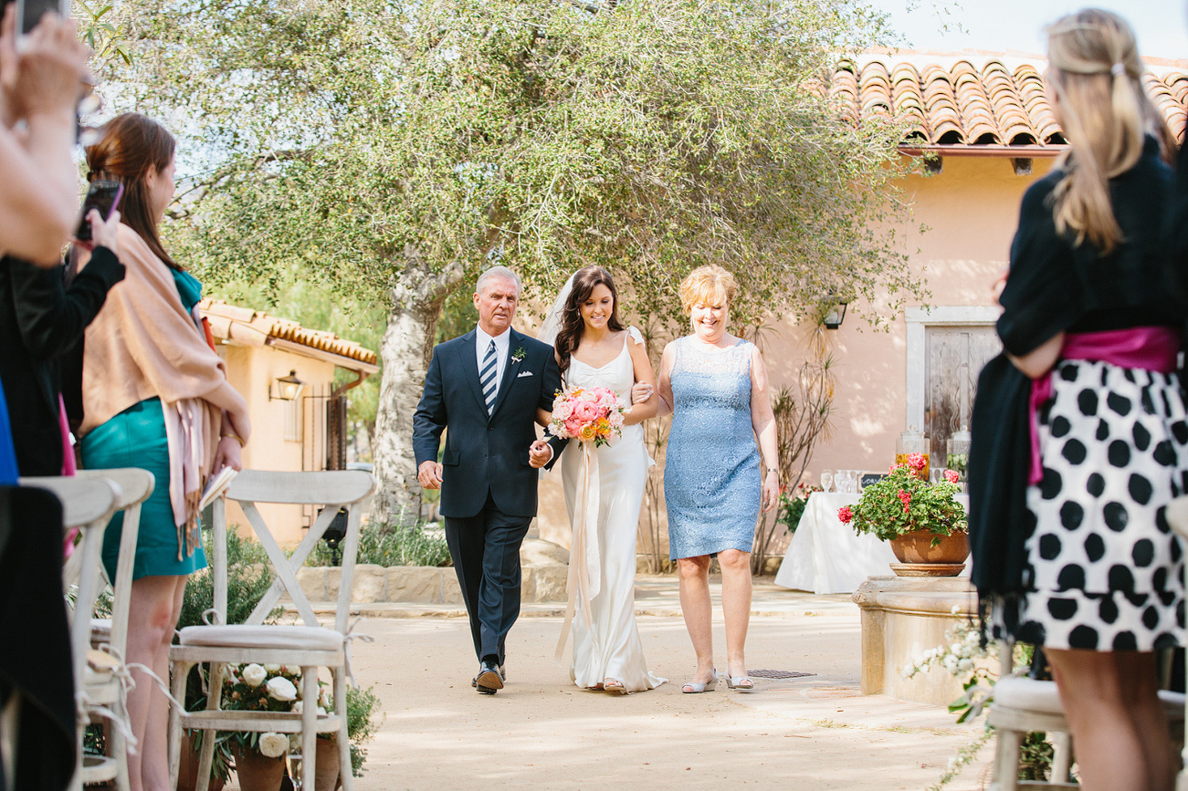 Katy walking down the aisle with her parents. 