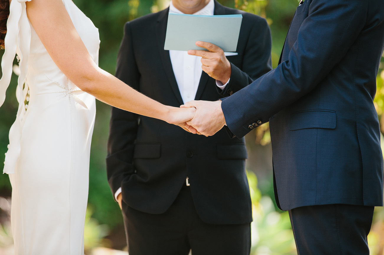 Andrew and Katy holding hands during the ceremony. 