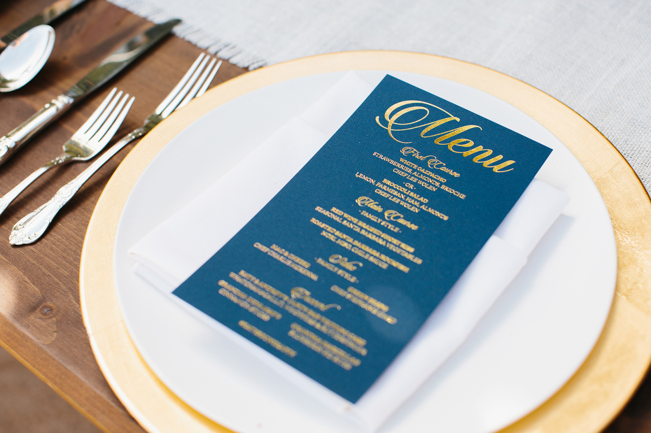 A photo of the navy blue and gold menu on the gold charger. 