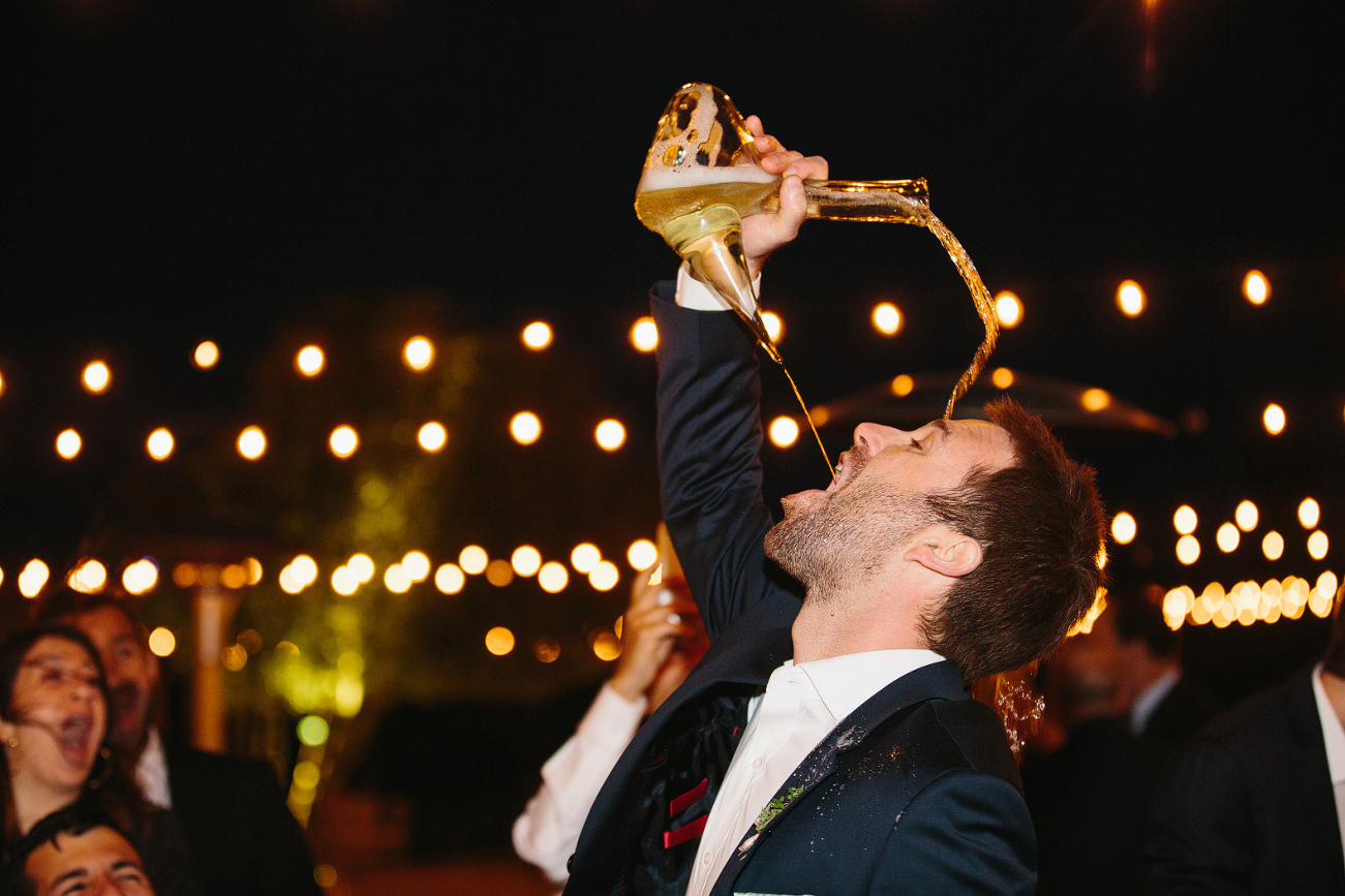 A groomsmen using the Spanish porron vessel and spilling it on his head. 
