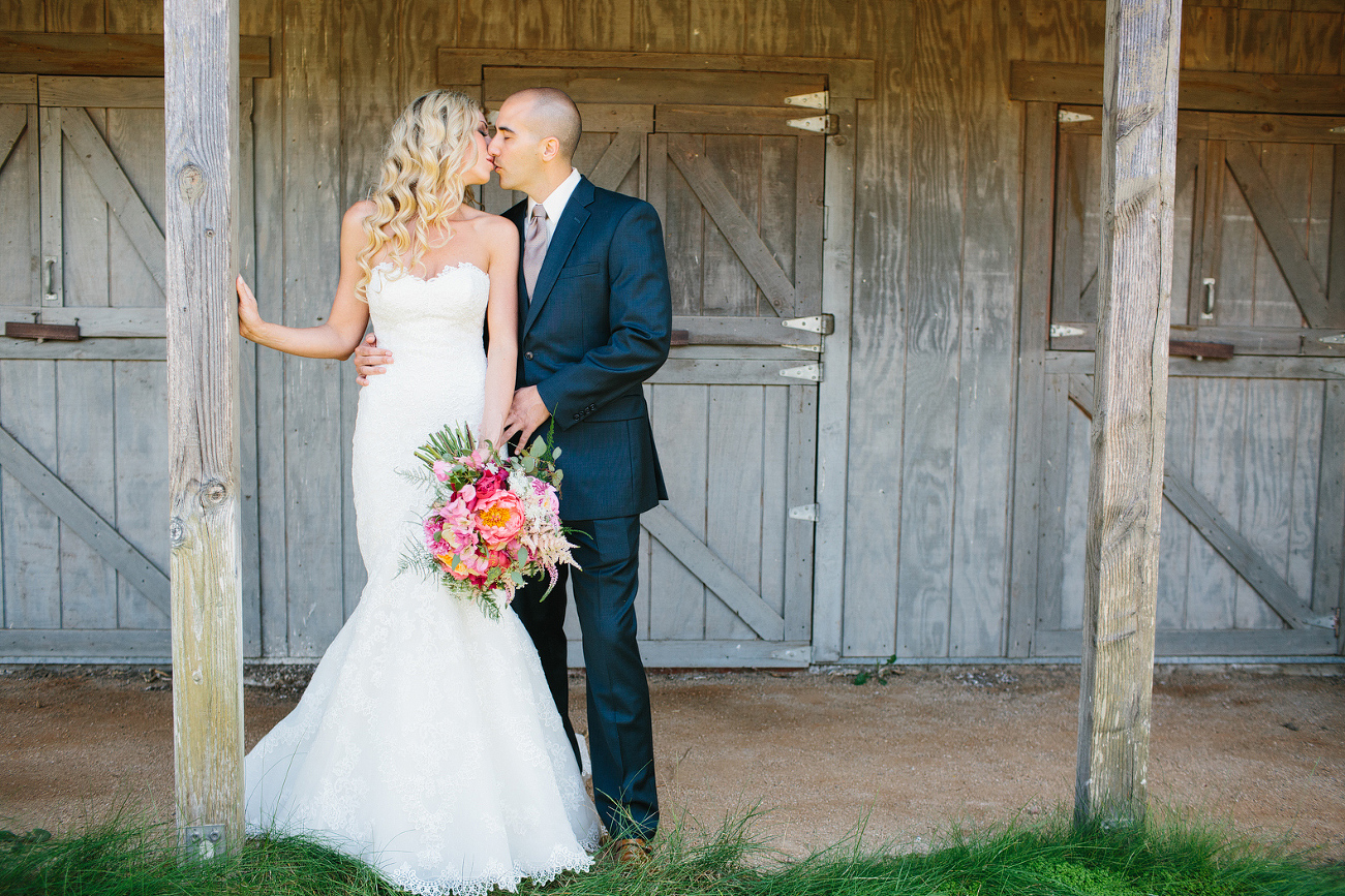 This is a photo of the couple kissing at the barn. 