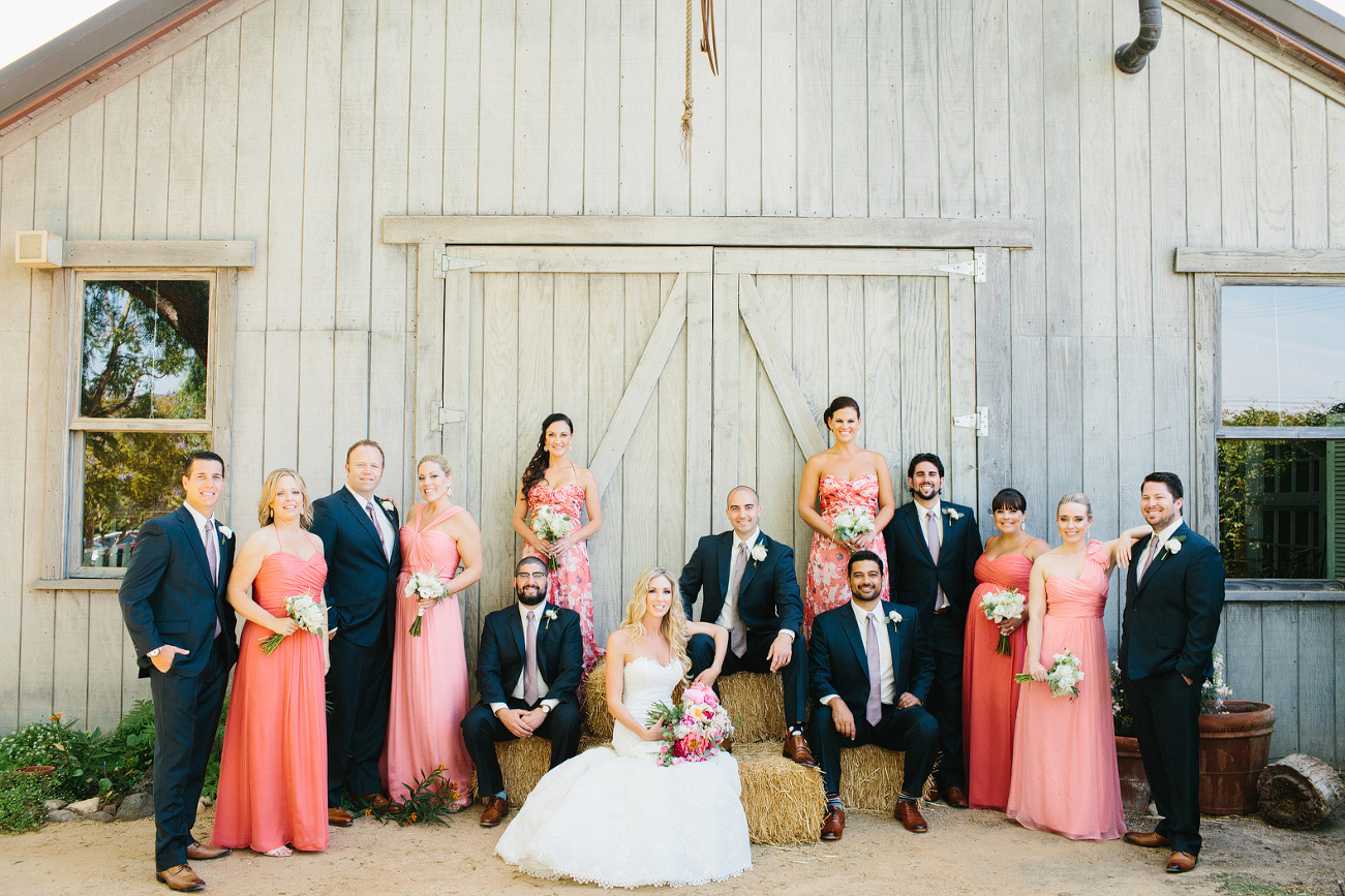 This is a photo of the wedding party in front of a barn. 