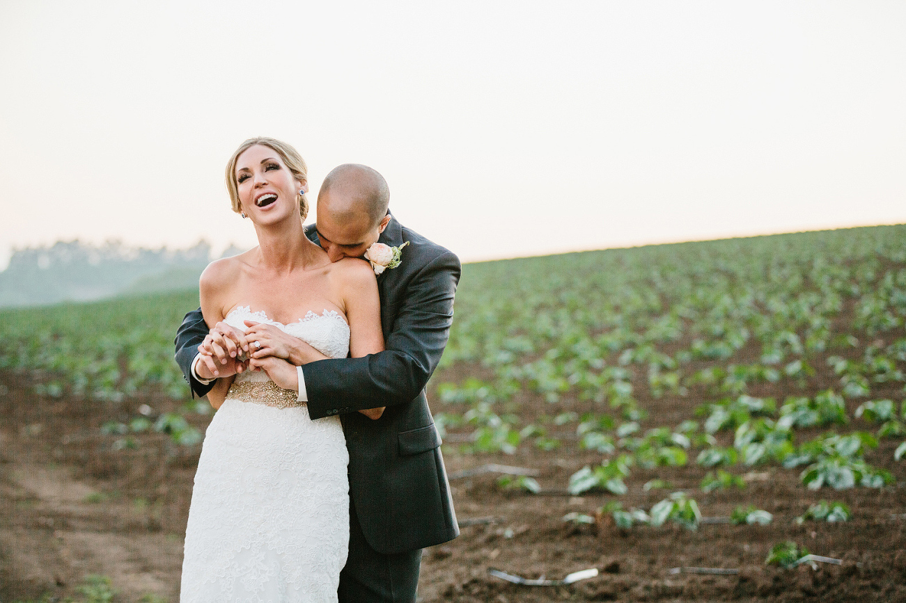 Here is a photo of the bride and groom hugging and laughing. 