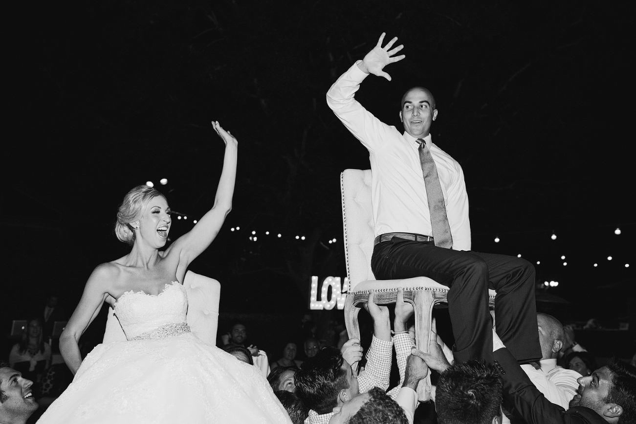 Here is a photo of the bride and groom during the reception being lifted on chairs. 