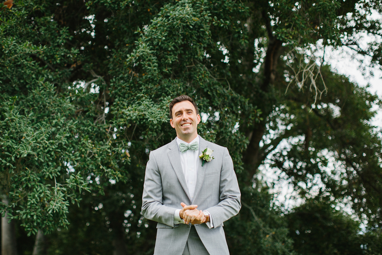 This is a photo of the groom in front of a large tree. 