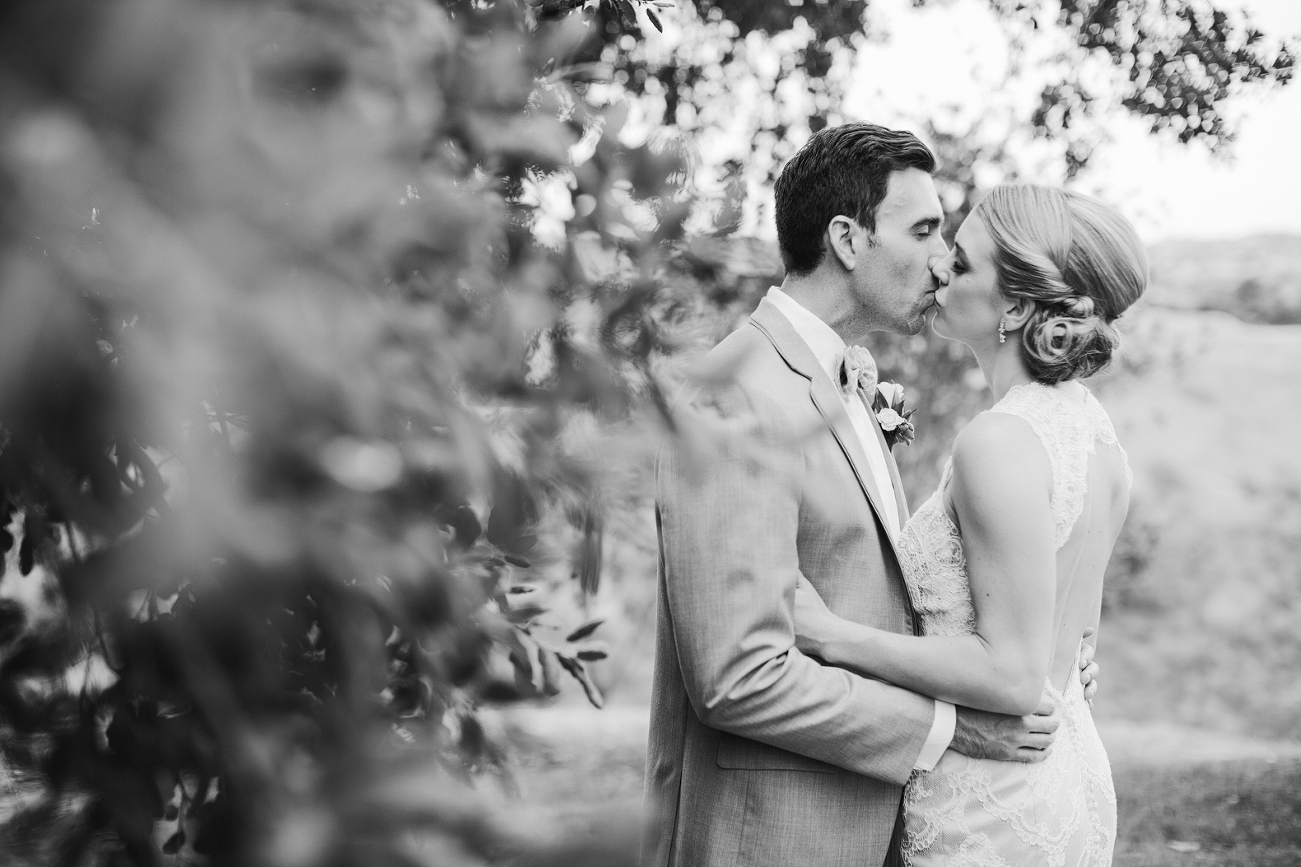 This is a black and white photo of the bride and groom kissing. 