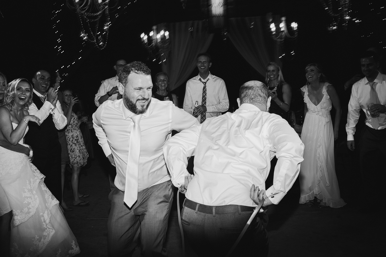 The groom dancing with a groomsmen. 