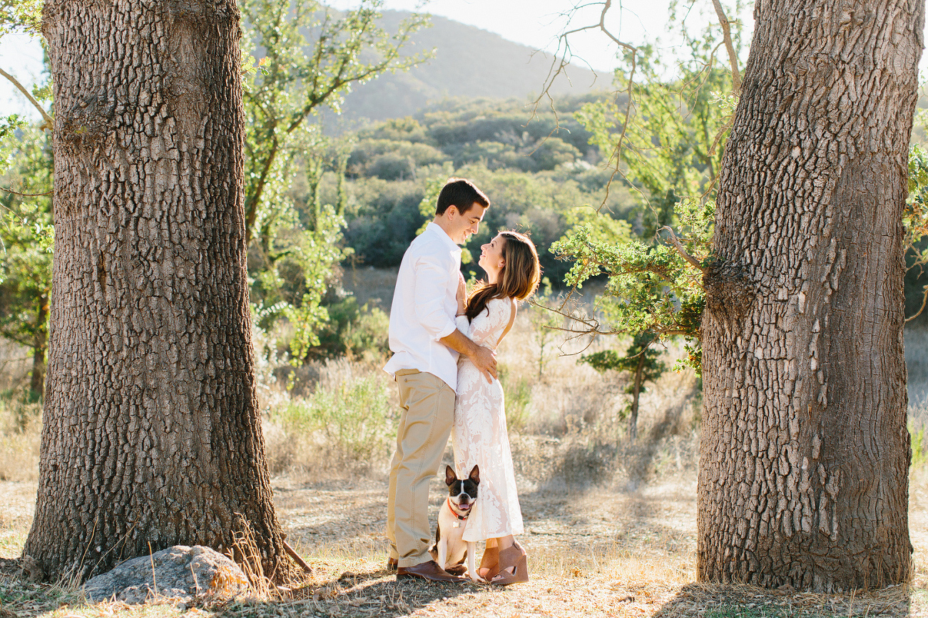 The dog standing between the couple. 