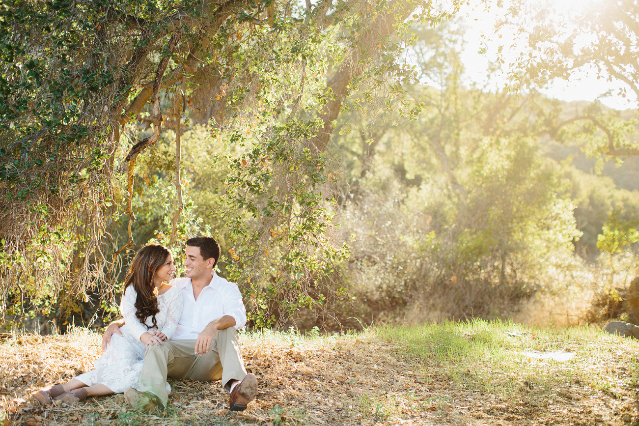 The couple sitting in the fields. 