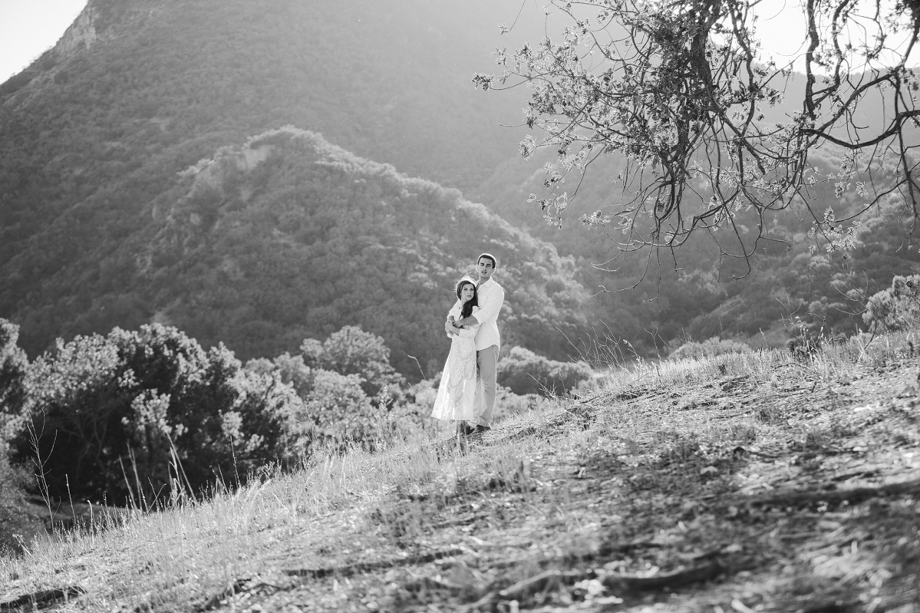 A black and white photo of the couple on the hillside.