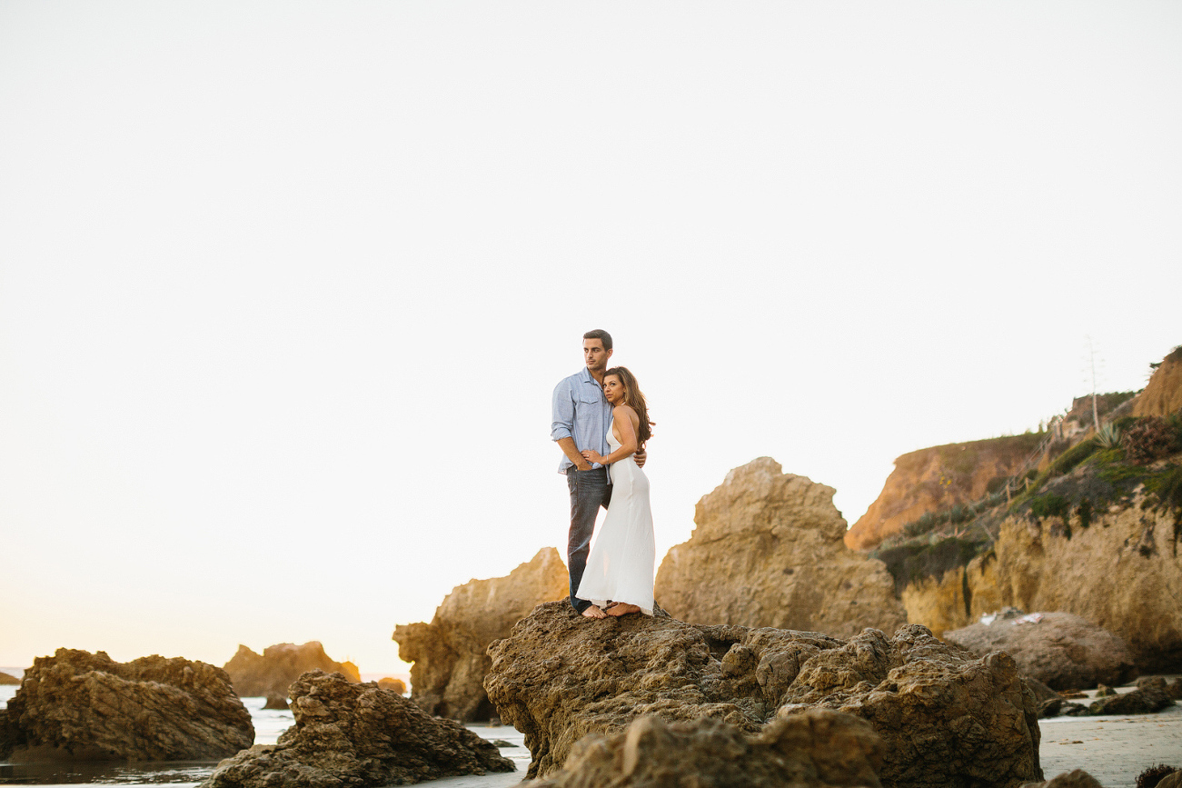 The couple standing on rocks. 
