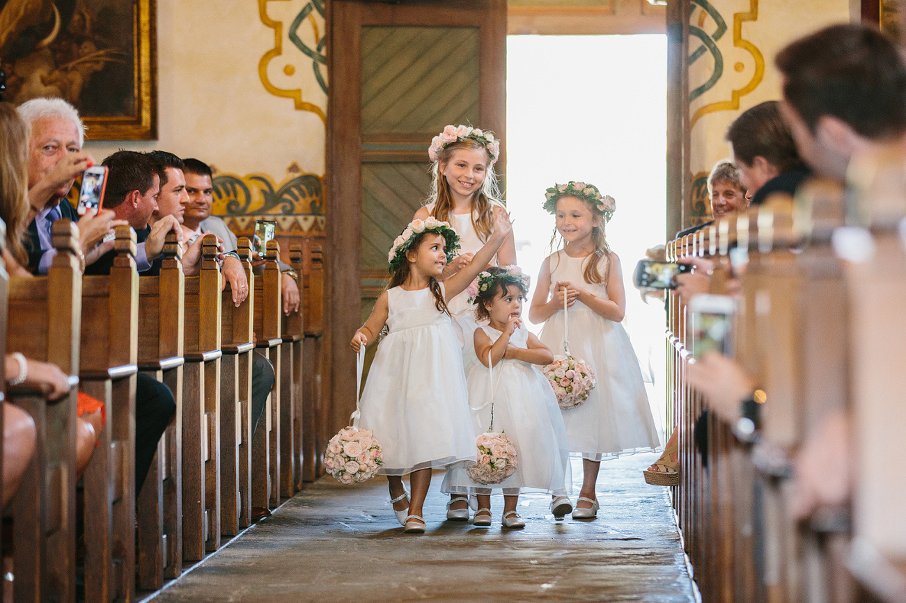 The flower girls walking down the aisle. 