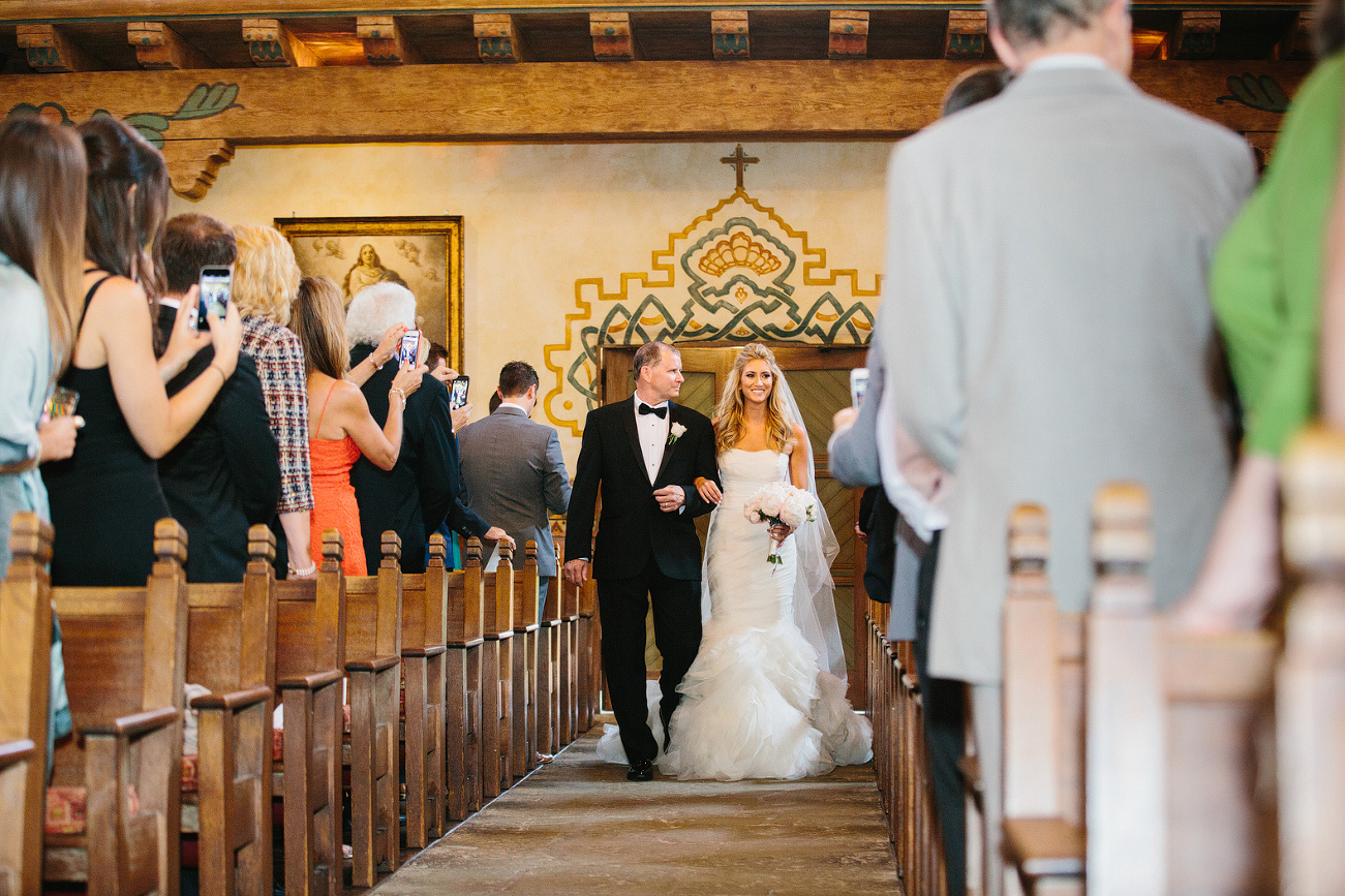 The bride walking down the aisle with her dad. 