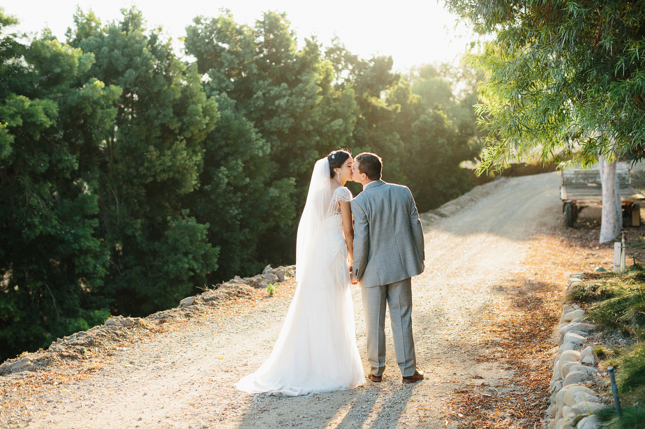 The bride and groom on a dirt path. 