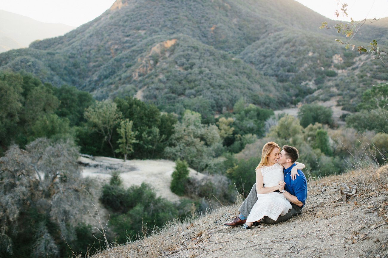 The couple sitting on the hillside. 