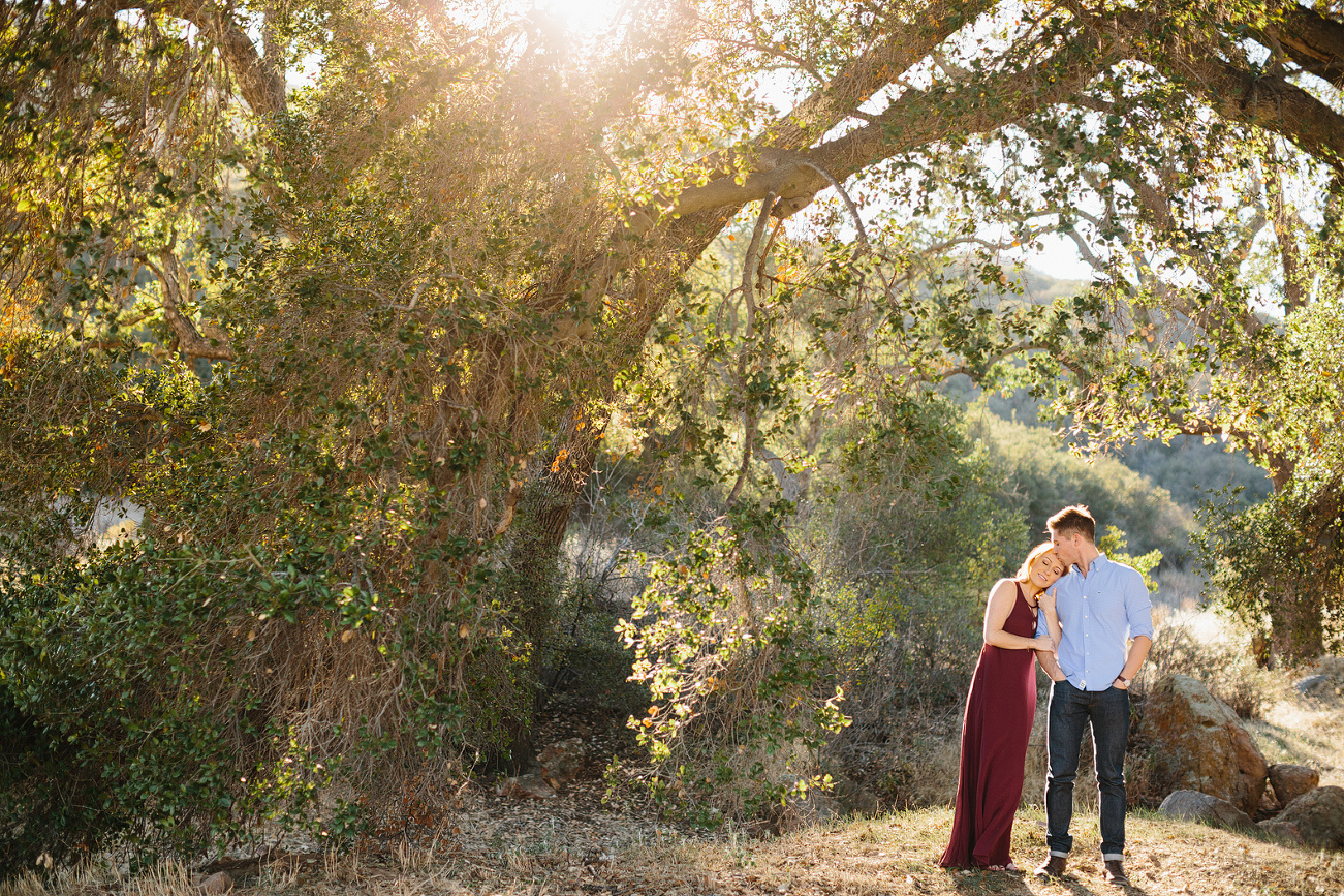 The couple standing under a large tree in the Malibu Hills. 