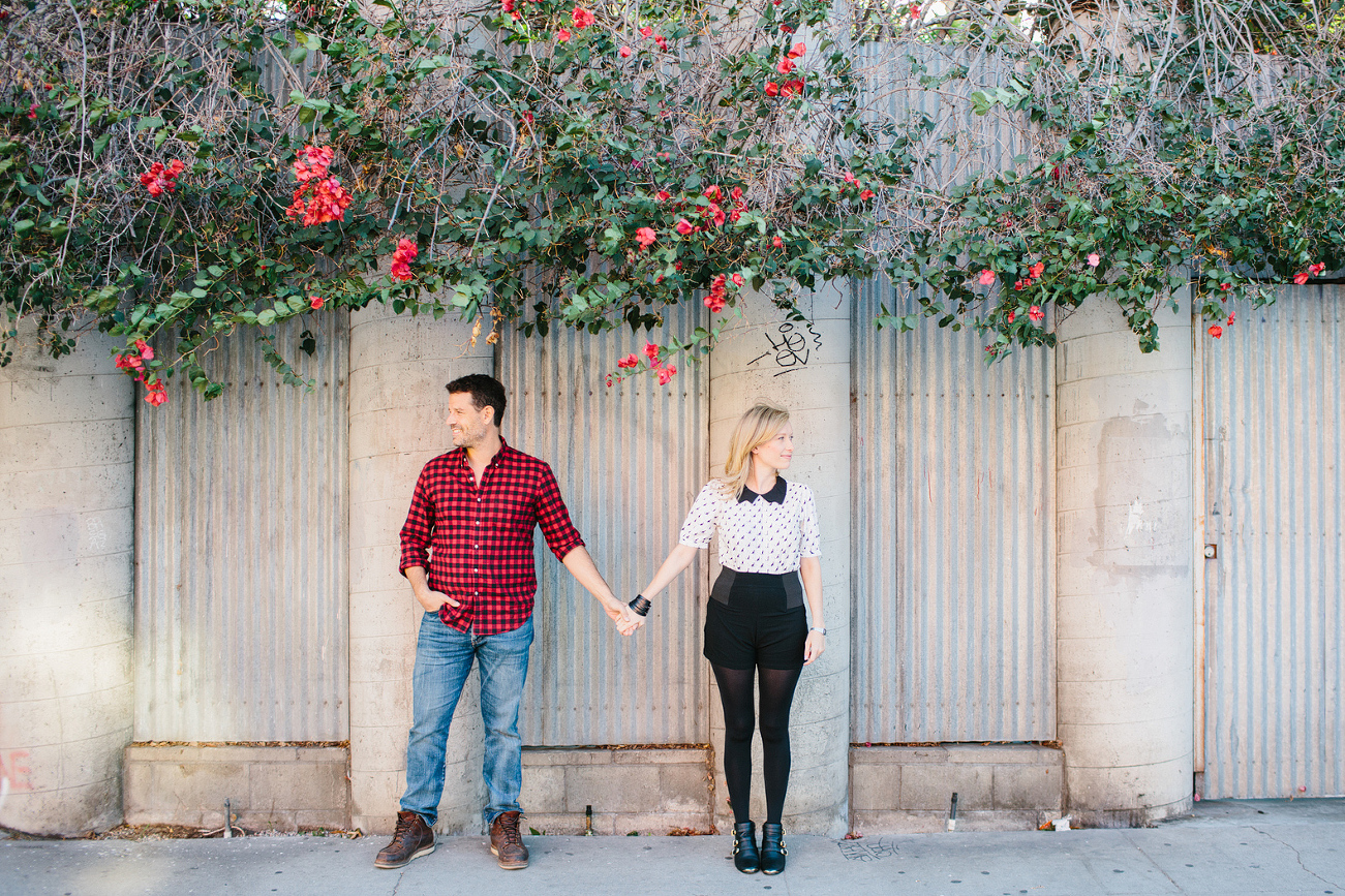 A cool shot of the couple standing under vines. 