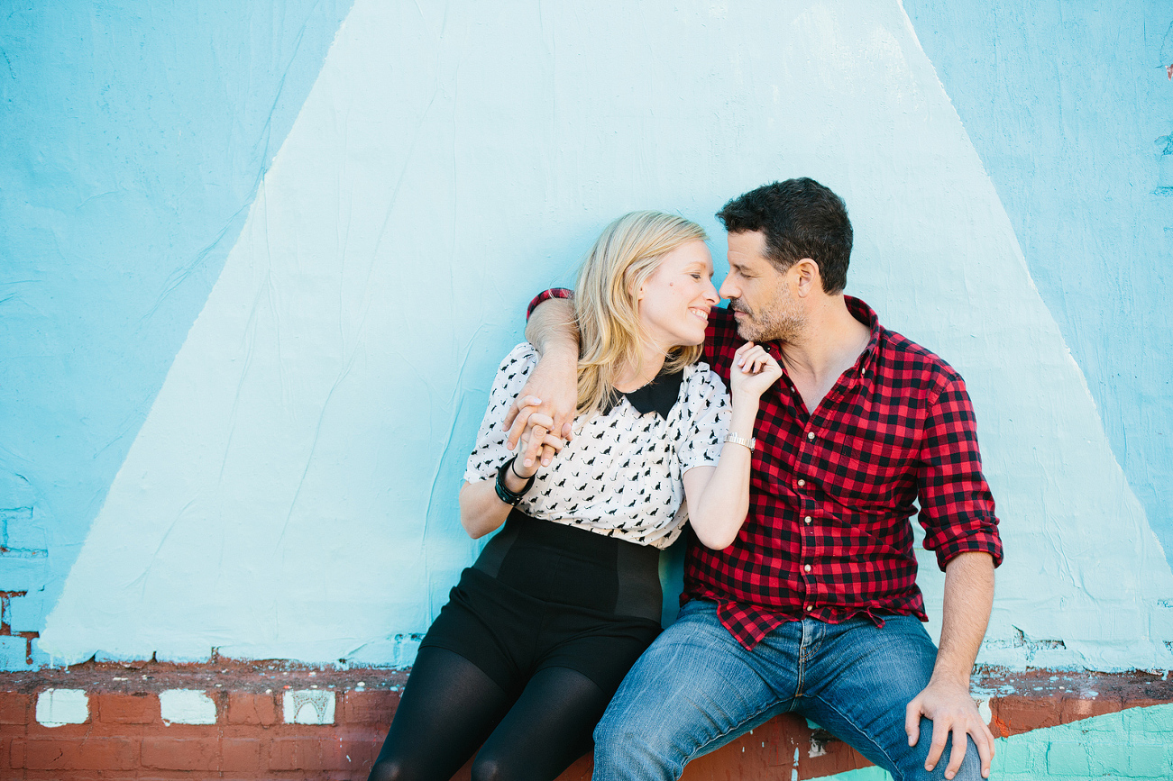 The couple sitting on a brick wall. 