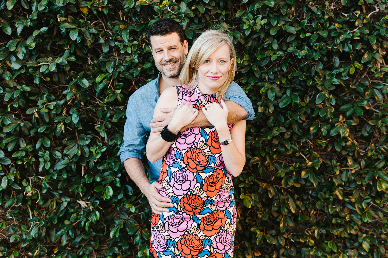 The couple in front of greenery. 