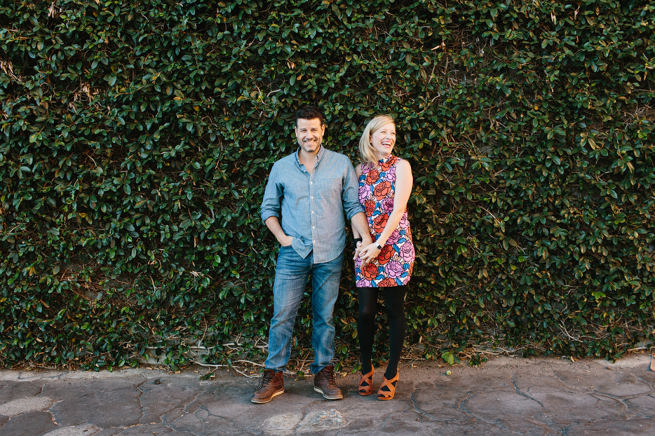Hayley and David in front of a wall covered in green plants. 