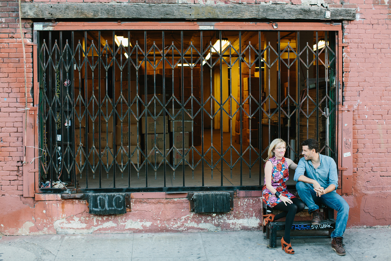 The couple sitting in front of a warehouse. 