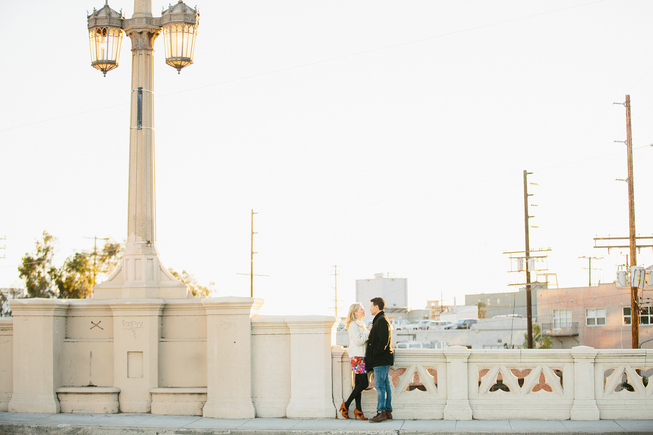 A beautiful photo of the couple standing on a bridge. 