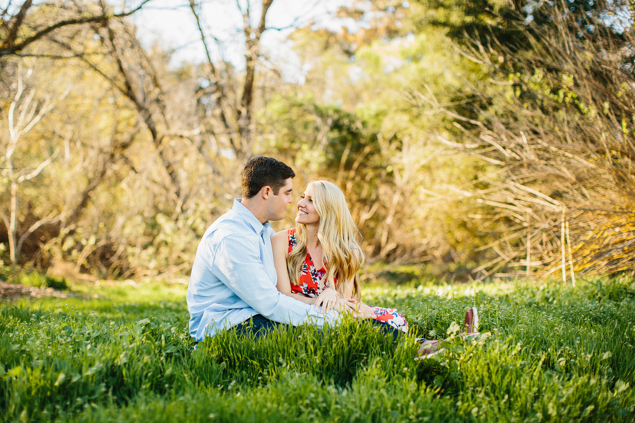 Britt and Steve sitting in the grass field. 