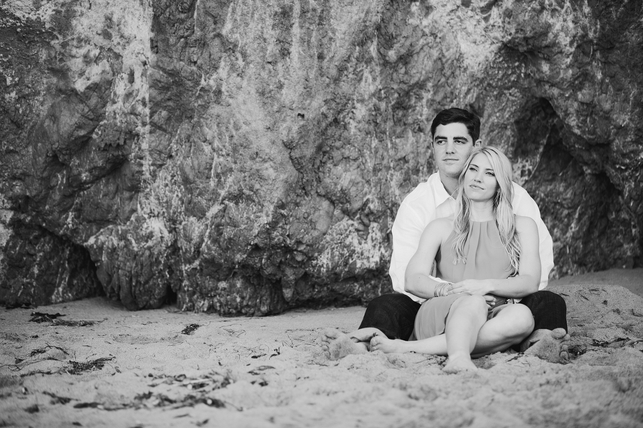 Britt and Steve sitting in front of the cliffside. 