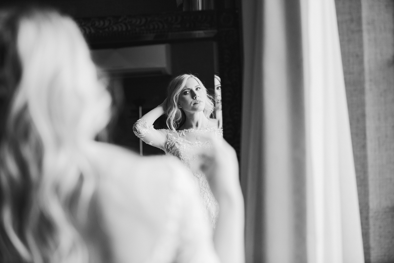 The bride fixing her hair in the mirror. 