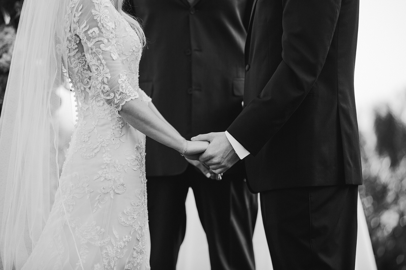 The bride and groom holding hands. 