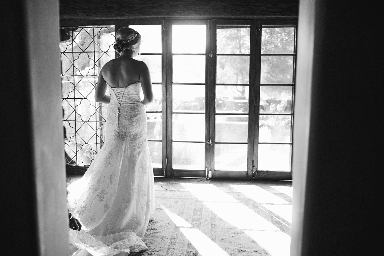 A black and white photo of the bride getting dressed. 