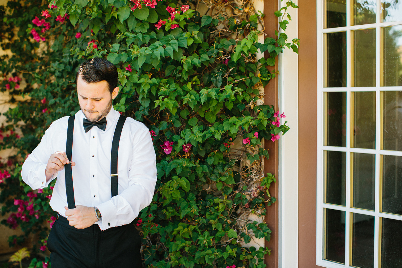 The groom tightening his suspenders. 