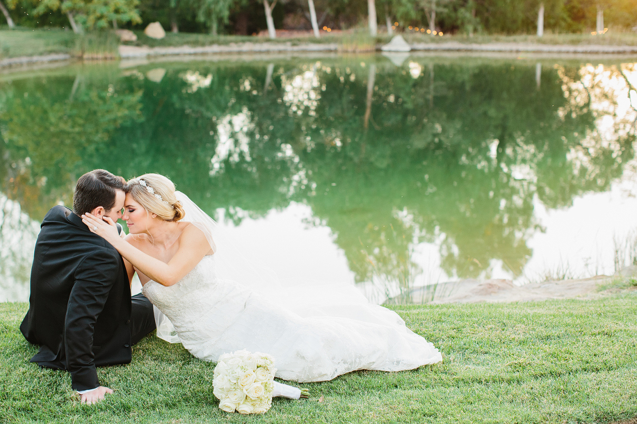 A sweet photo of the couple sitting by the lake. 