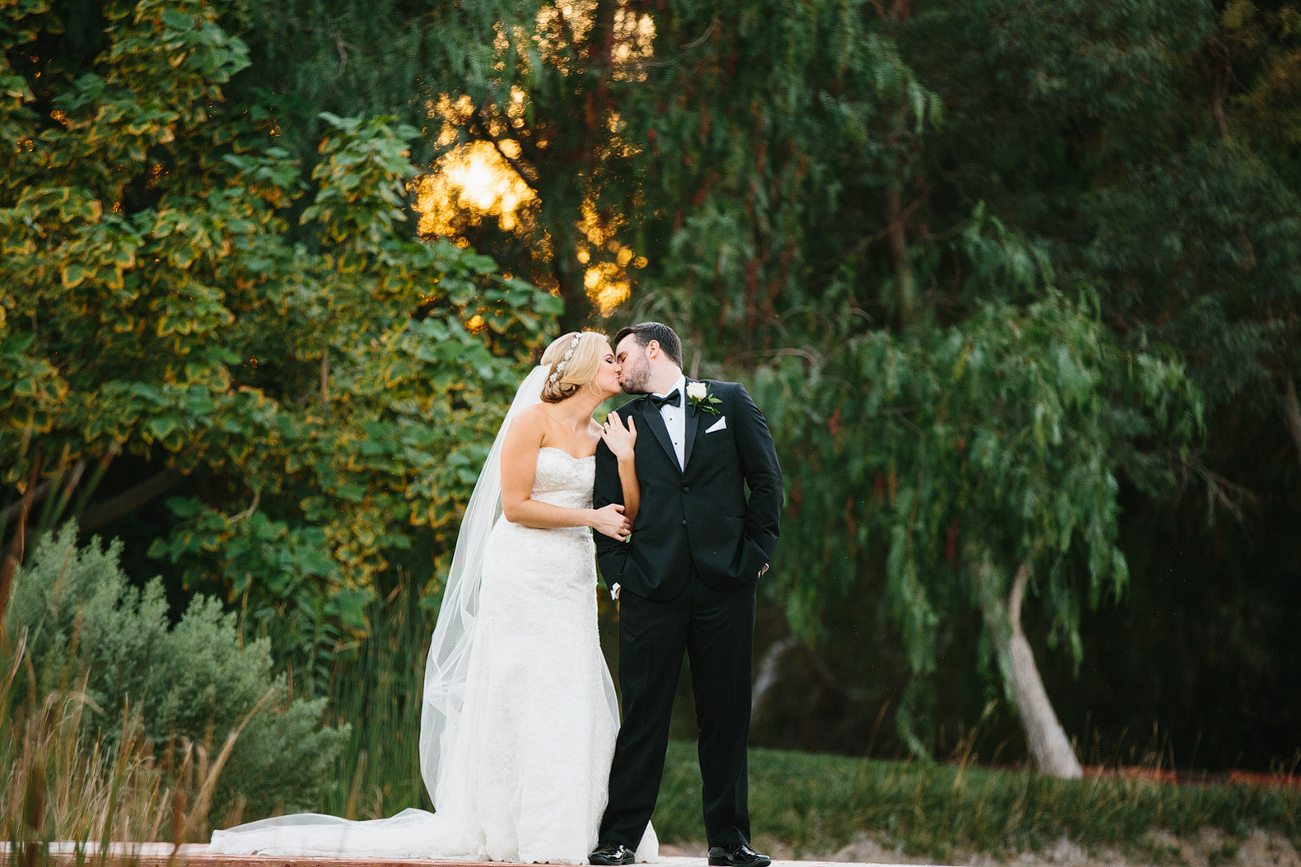 The couple in front of large trees. 