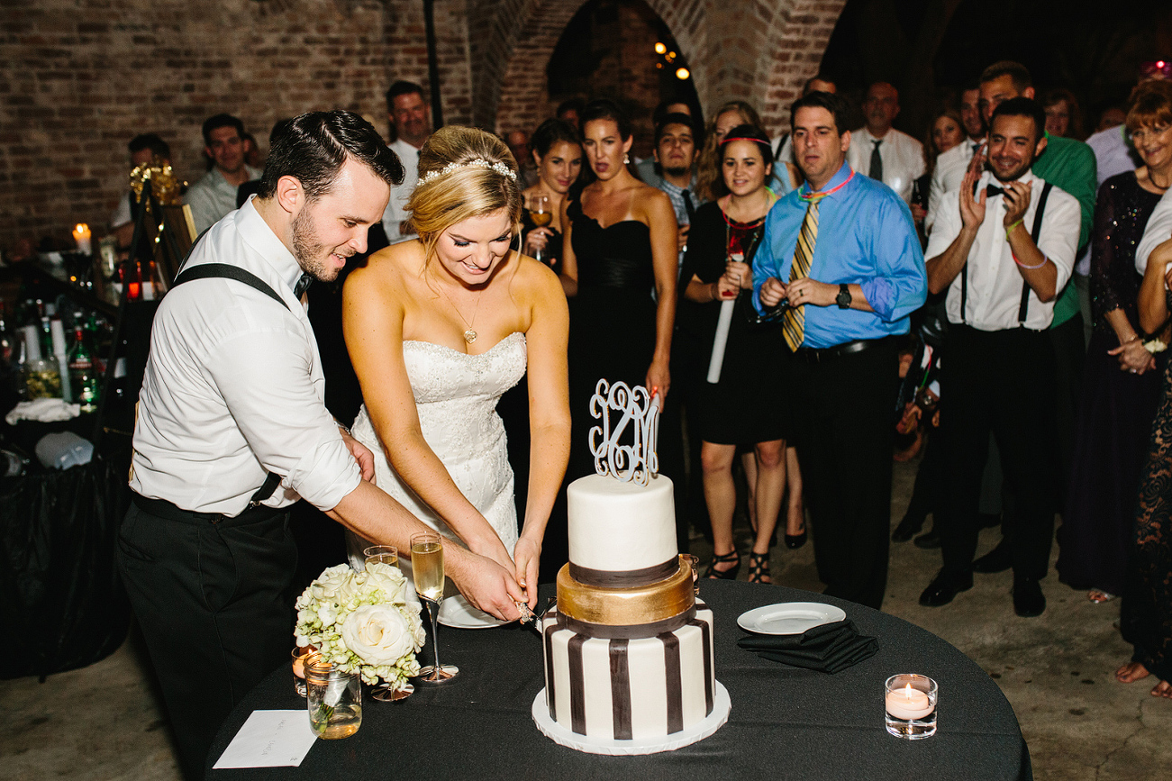 Guests watching the couple cut the cake. 