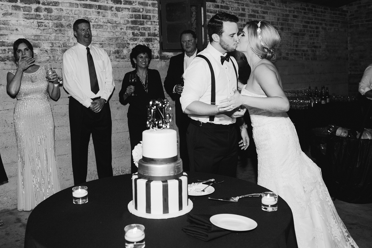 The couple kissing after cake cutting. 