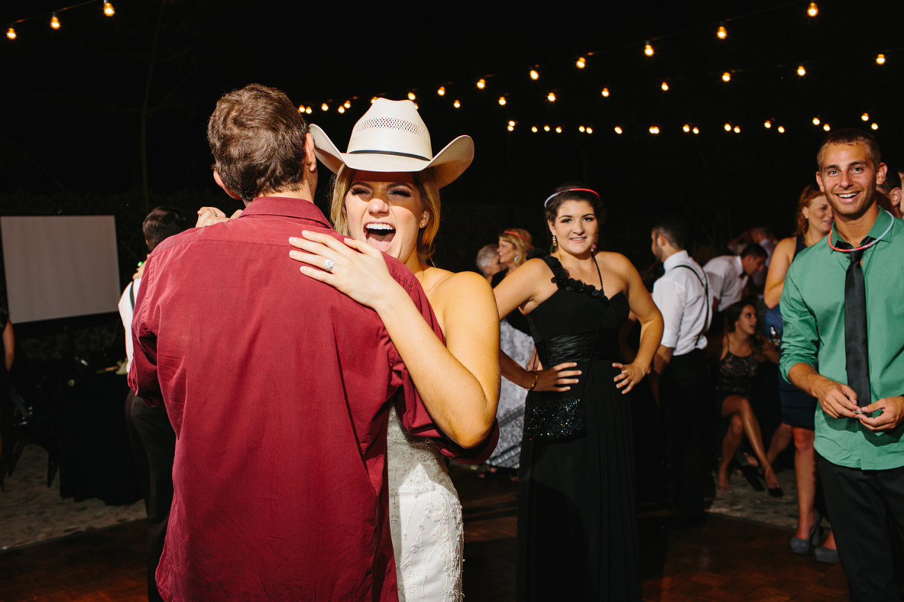 The bride dancing in a cowboy hat. 