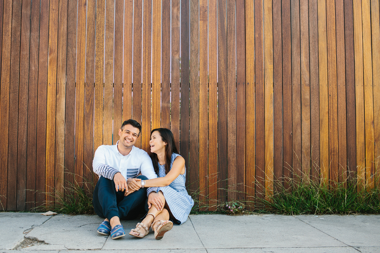 The couple sitting on the sidewalk. 