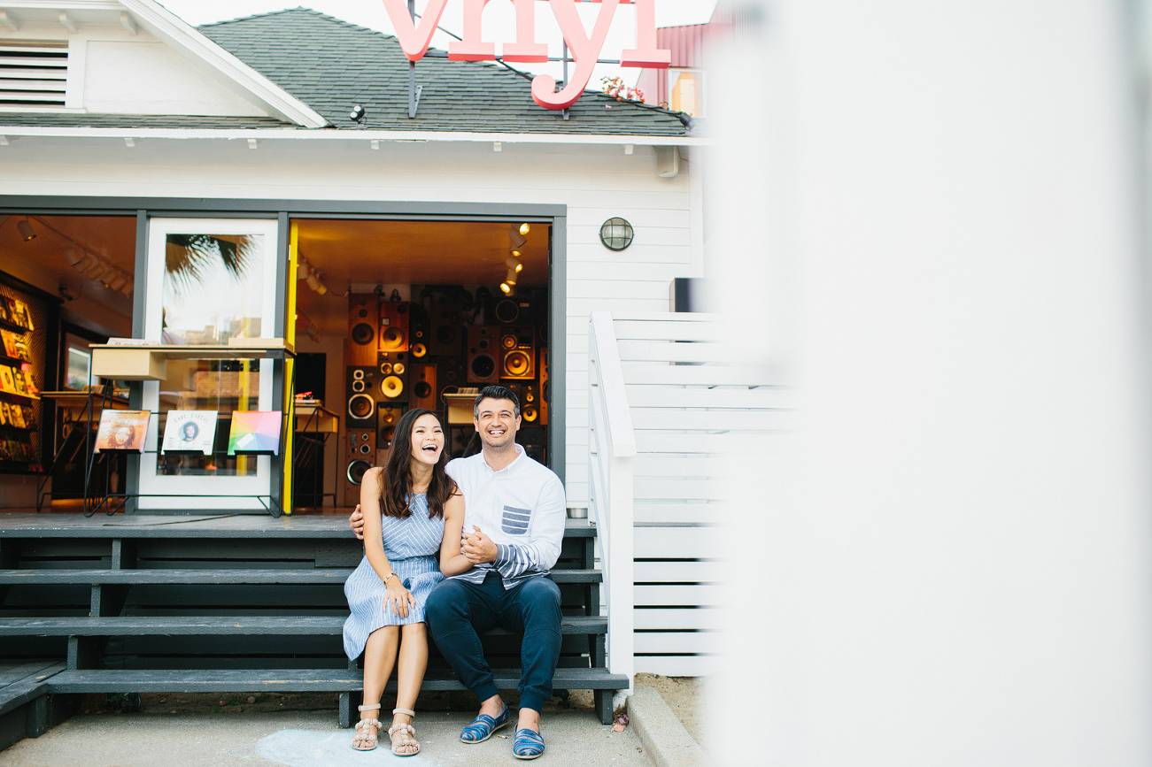 The couple laughing on store steps. 