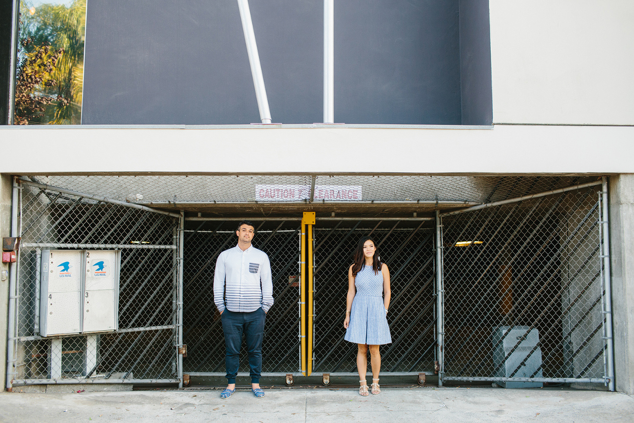 The couple in front of a fence. 