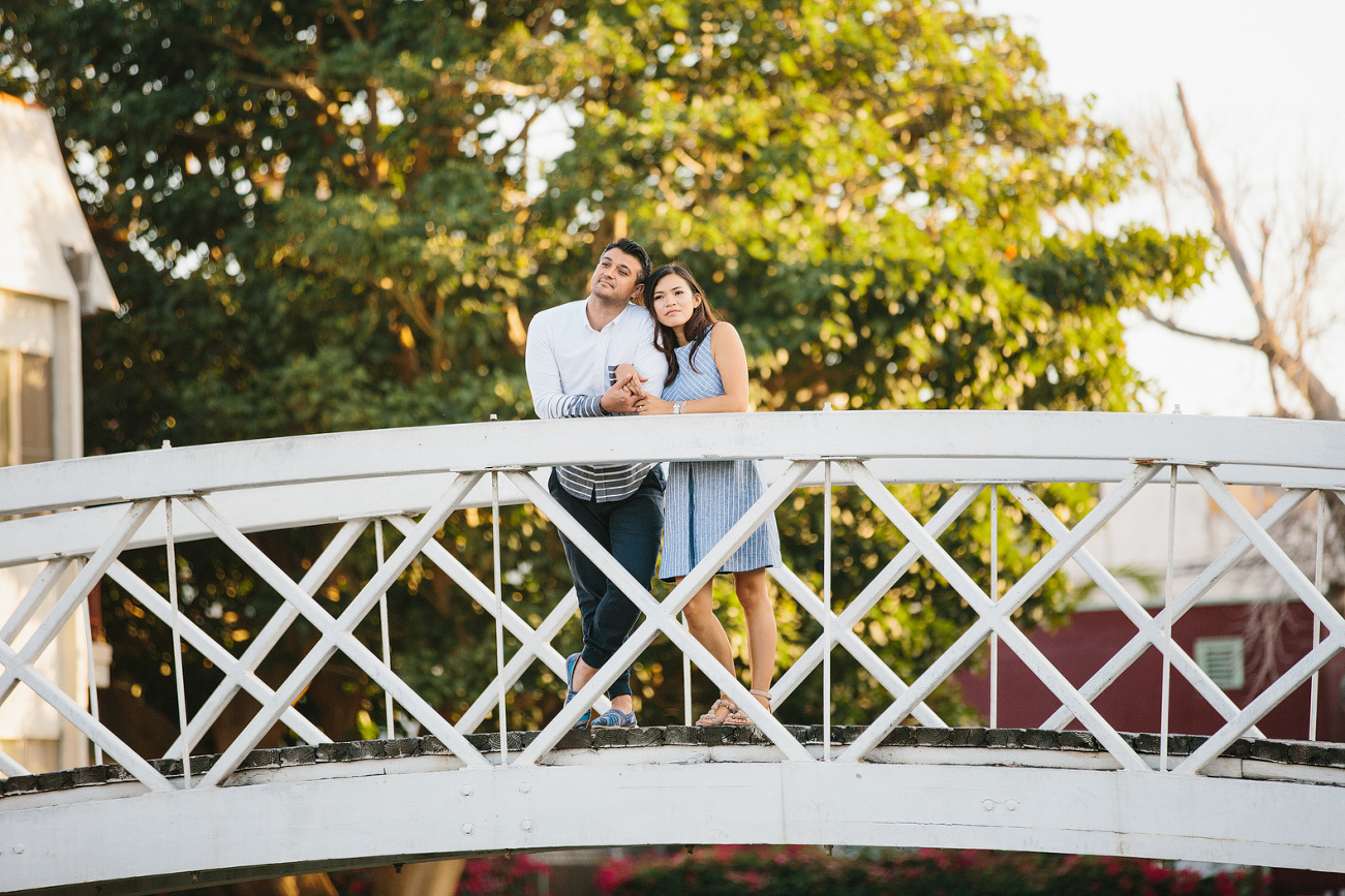 A portrait of the couple on a bridge. 