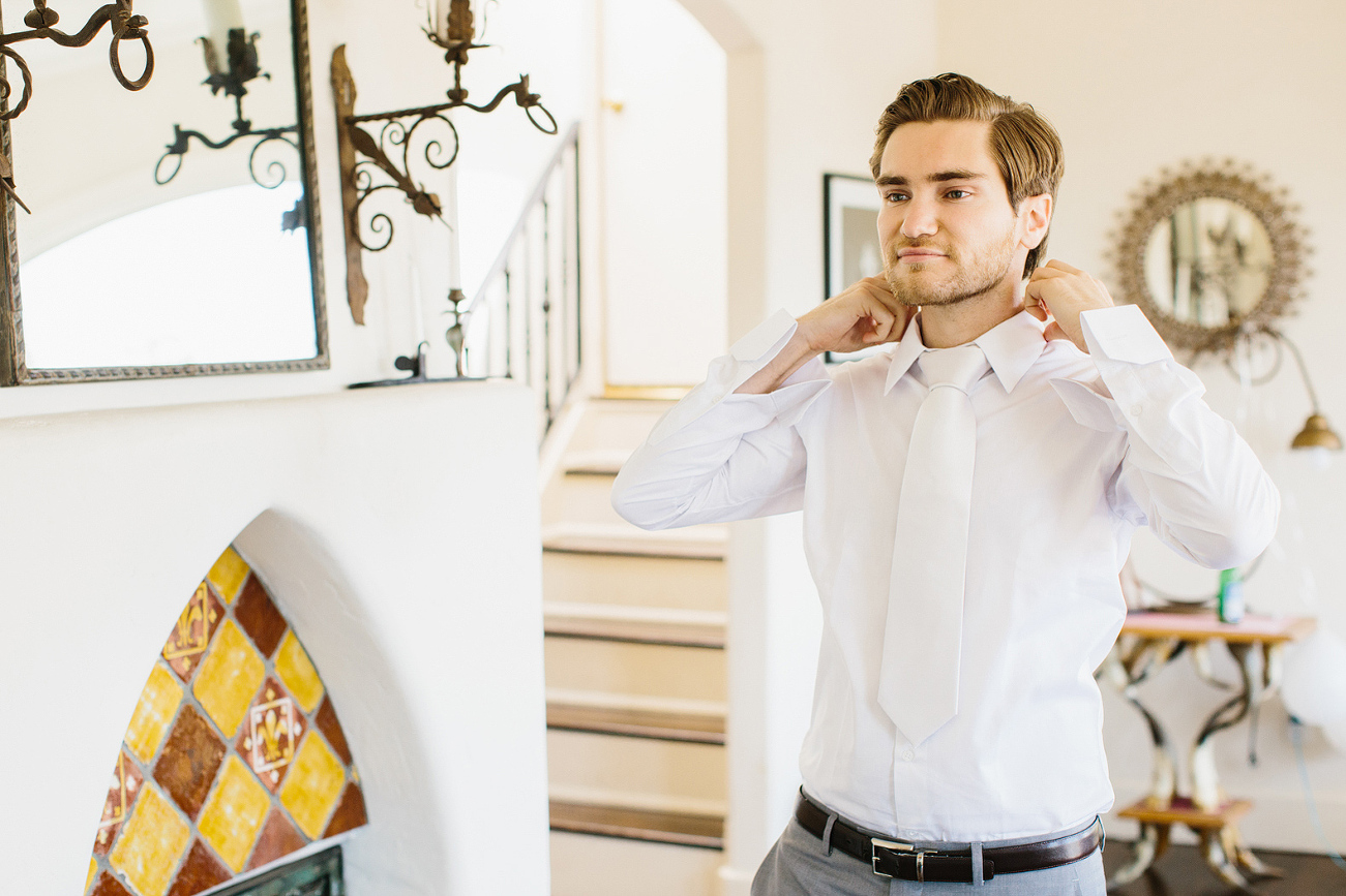 The groom adjusting his collar. 