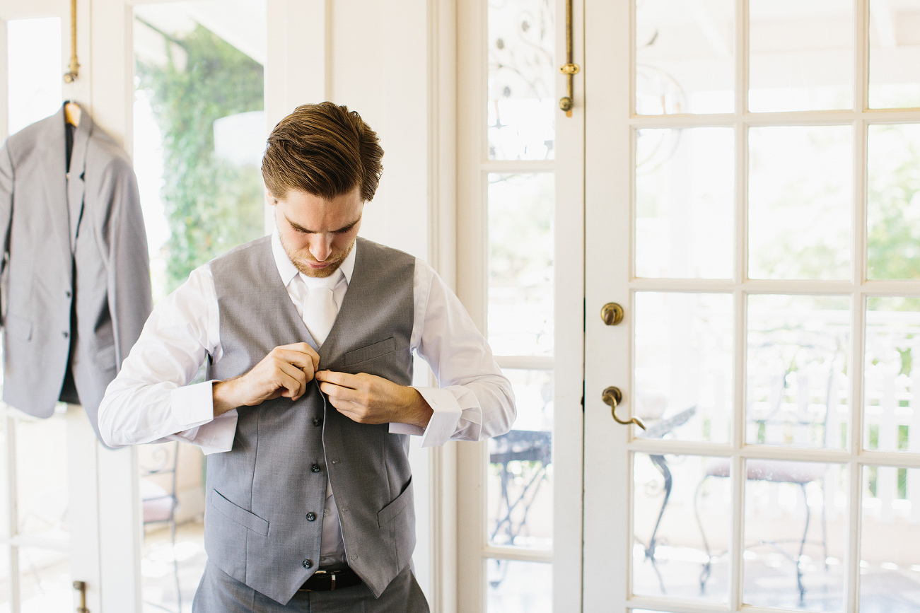 Dan buttoning his vest up. 