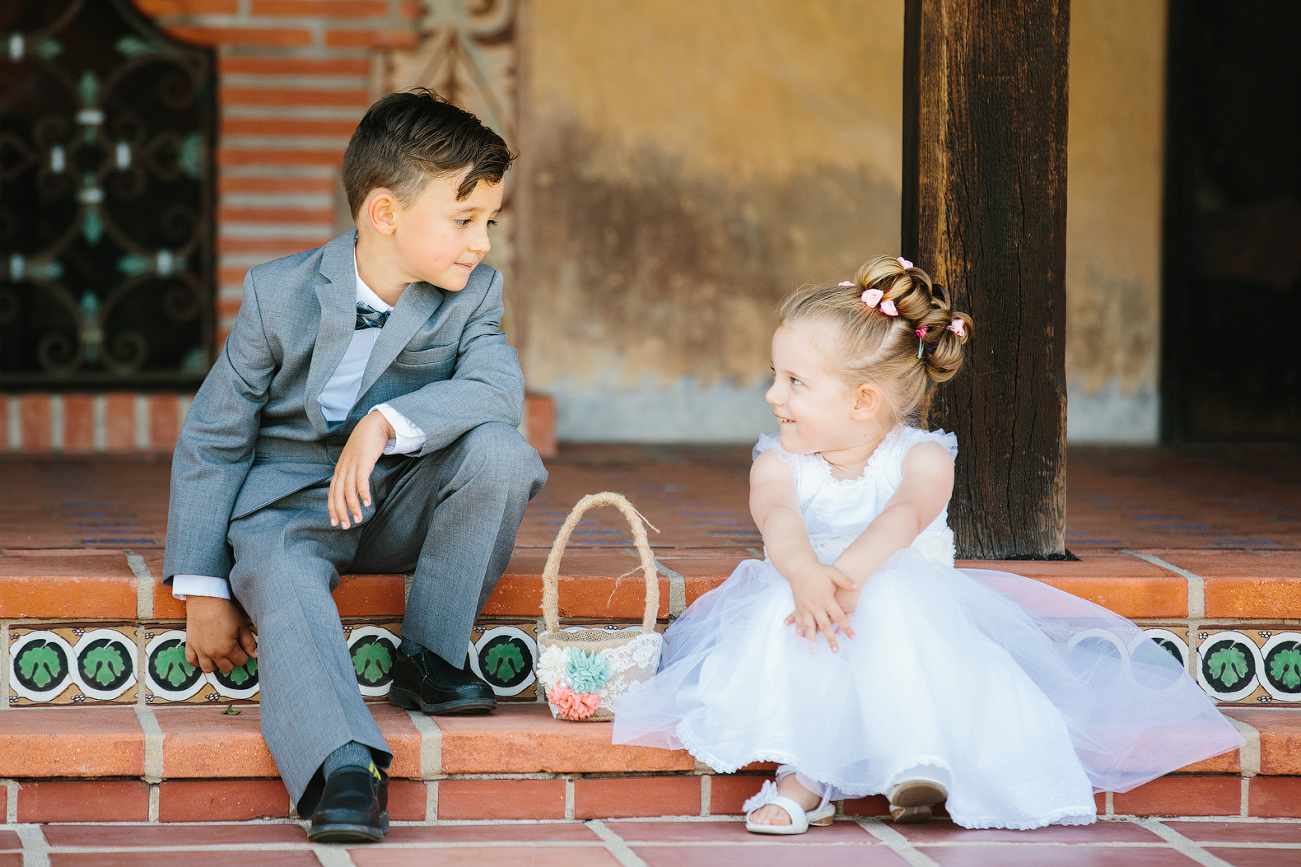 The adorable flowergirl and ring bearer sitting together. 
